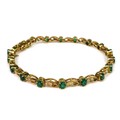 A gold, emerald and diamond bracelet, formed of oval cut emeralds each of approximately 4 by 3mm and... 