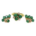 A gold, emerald and diamond ring, formed of three oval cut emeralds, each of approximately 5 by 3mm,... 