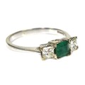 An 18ct white gold, emerald and diamond ring, the central square cut emerald of approximately 4 by 4... 