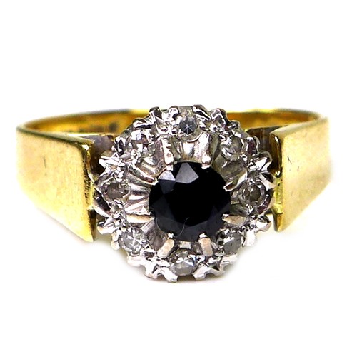 270 - An 18ct gold, sapphire and diamond ring, the central dark sapphire of approximately 3.5mm diameter a... 