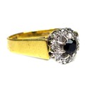 An 18ct gold, sapphire and diamond ring, the central dark sapphire of approximately 3.5mm diameter a... 