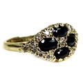 An 18ct yellow gold ring, set with four oval cut dark blue sapphires, 6 by 3 by 3mm, amongst fifteen... 