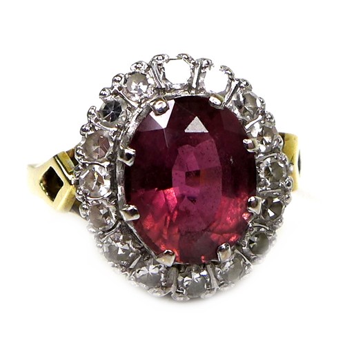 282 - An 18ct yellow gold dress ring, set with an oval cut red/purple coloured stone, approximately 10 by ... 