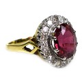 An 18ct yellow gold dress ring, set with an oval cut red/purple coloured stone, approximately 10 by ... 