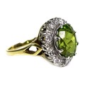 An 18ct yellow gold dress ring, set with an oval cut green coloured stone, likely peridot, approxima... 