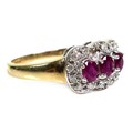 An 18ct gold and ruby three stone ring, each stone of approximately 4 by 3.5mm, with diamond chips t... 