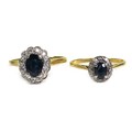 An 18ct gold and sapphire ring, of dark colour and oval cut, approximately 5.5 by 4mm, surrounded by... 