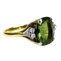 An 18ct yellow gold dress ring, set with a rectangular cushion cut olive green coloured stone, appro... 