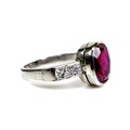 A platinum, ruby and diamond ring, the central oval cut ruby measuring approximately 9.3 by 7.4 by 5... 