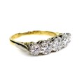 An 18ct gold and diamond five stone ring, the graduating stones illusion set in platinum, largest me... 