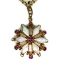 A 9ct gold ruby and opal daisy form pendant, with seven round cut rubies, 2mm diameter, six opals7mm... 