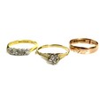 A group of three gold dress rings, comprising an 18ct gold three stone illusion set diamond ring, th... 