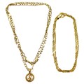 Two 9ct gold necklaces, comprising a figaro link necklace, with a 9ct gold pendant, formed as a circ... 