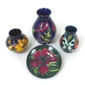 A group of four pieces of Moorcroft pottery, comprising a baluster vase, 9 by 13cm high, two spill v... 