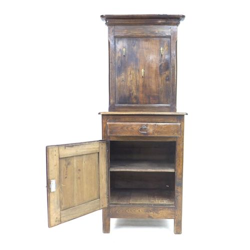 245 - An early 19th century French oak wash stand, its top section with later fitted brass coat hooks, its... 