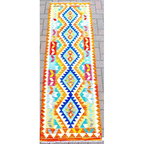 261 - A Chobi Kilim runner, decorated with a row of five lozenges along its center, 196 by 66cm.