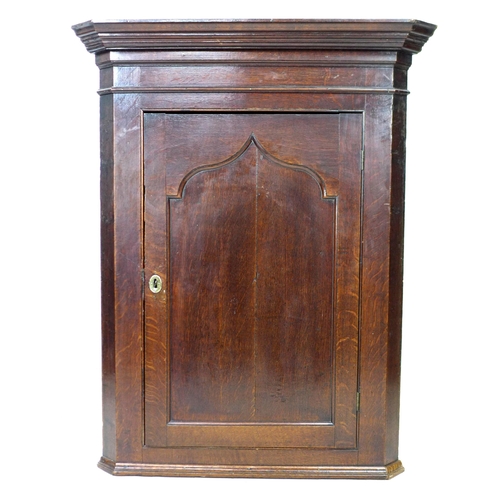 268 - A George III oak corner cupboard, with flat front, pointed arch panel door, its interior with two sh... 