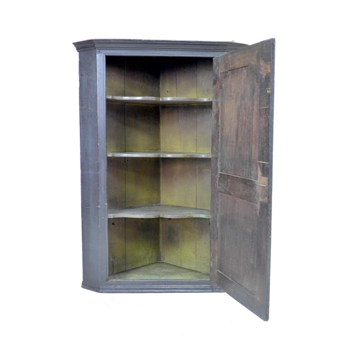 270 - A George III oak corner cupboard, with a single flat front fielded panel door, fixed shelves to inte... 