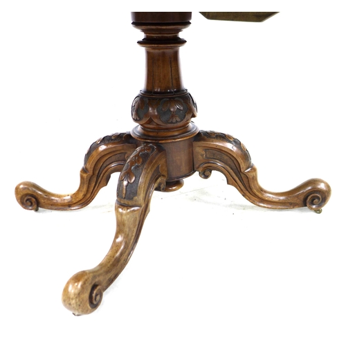 279 - A Victorian burr walnut loo table, with oval tilt top, carved baluster column and four carved cabrio... 