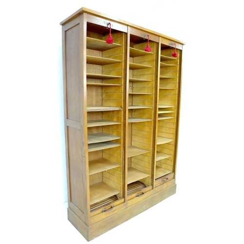 285 - An early to mid 20th century oak tambour fronted filing unit, with three vertical sections, each wit... 