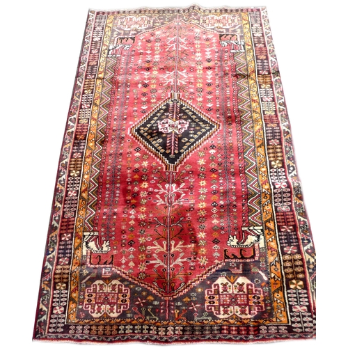 286 - A Shiraz rug, with central diamond on red ground and geometric floral borders, 242 by 148cm.