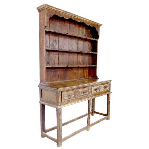 293 - An 18th century oak dresser, the closed back plate rack with three shelves fitted with brass hooks, ... 