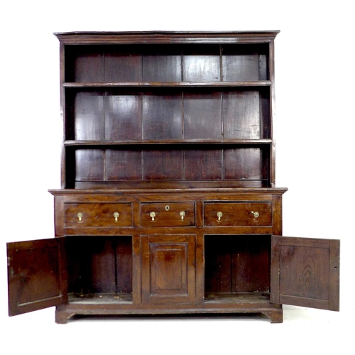 297 - A George III oak dresser, the closed back plate rack with two shelves, the base section with three f... 