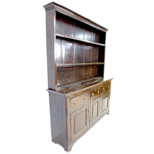 297 - A George III oak dresser, the closed back plate rack with two shelves, the base section with three f... 