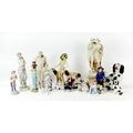 A group of porcelain and plaster figurines, including a Meissen style figural group of a cherub with... 