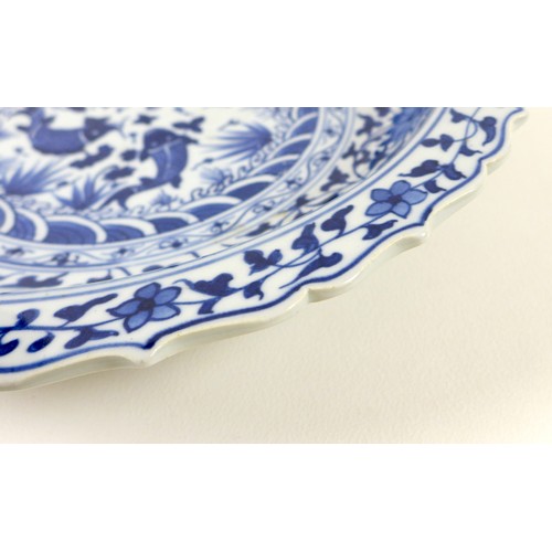47 - A Chinese Ming style blue and white porcelain dish, late 20th century, with scalloped rim, decorated... 