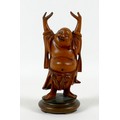 A Chinese carved wooden figure of a Buddha, modelled standing with his arms raised, on a turned base... 