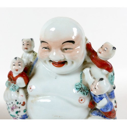 41 - A Chinese porcelain figure, modelled as a Buddha with five children, decorated in famille rose palet... 