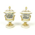 A pair of early 19th century Derby campana urns, with inner linings, covers and twin handles, painte... 