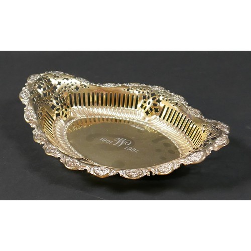 30 - An Edwardian silver gilt commemorative bowl, of boat form with pierced sides and repousse scrolls to... 
