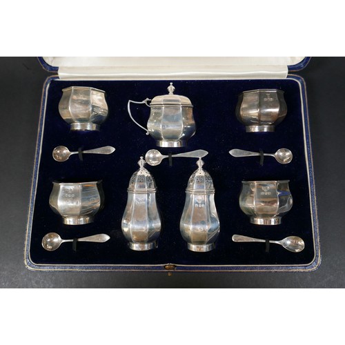 44 - A George V silver cruet set, with fitted case, comprising a mustard pot with blue glass line 7 by 5 ... 