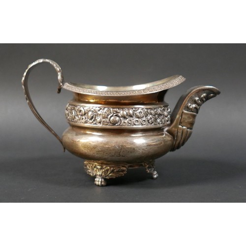 78 - A large George III silver milk jug, with decorative floral border and encrusted rim, raised on three... 