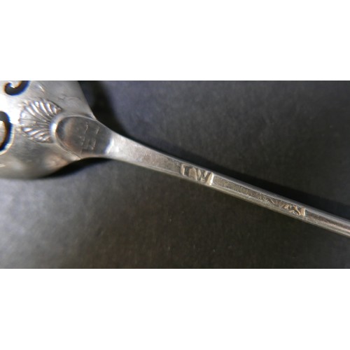 55 - An 18th century silver mote spoon, the oval bowl with scroll piercings, shell clasped, and engraved ... 