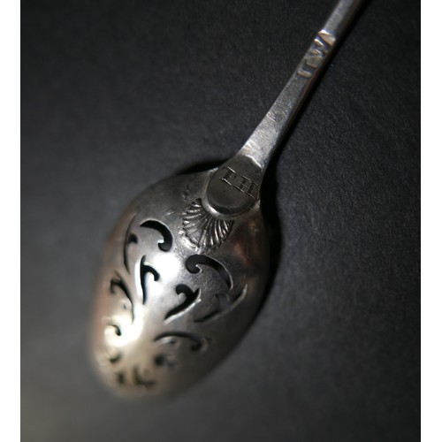 55 - An 18th century silver mote spoon, the oval bowl with scroll piercings, shell clasped, and engraved ... 