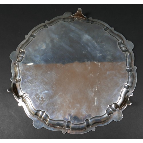 121 - A silver tray, circular form with scalloped edge, engraved decoration, raised on three feet, 3 by 35... 