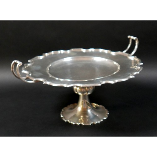 122 - A silver twin handled pedestal dish, circular surface with shallow central well, raised on a taperin... 