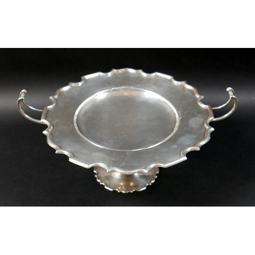 122 - A silver twin handled pedestal dish, circular surface with shallow central well, raised on a taperin... 