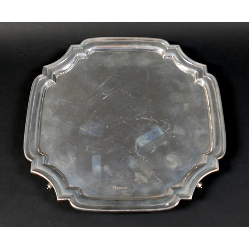 98 - A silver tray, of square form with incuse corners, raised upon four scroll feet, 3 by 26.5cm, 21.7to... 