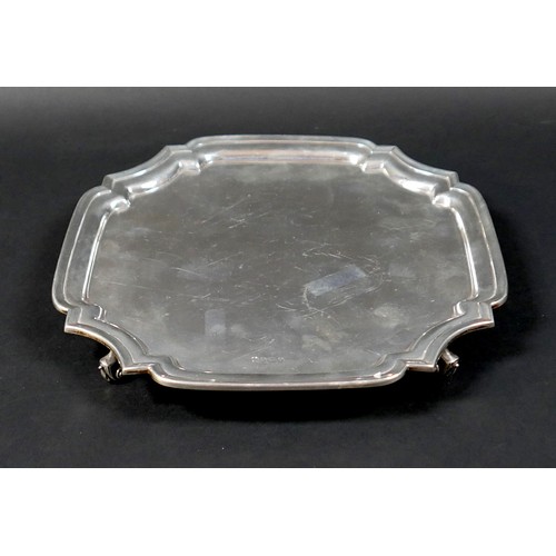 98 - A silver tray, of square form with incuse corners, raised upon four scroll feet, 3 by 26.5cm, 21.7to... 