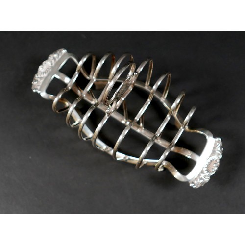 36 - A George III silver six division toast rack, with heart shaped dividers and shell handles, raised on... 