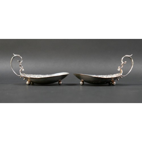51 - A pair of American Sterling silver dishes, early 20th century, the oval bowls cast with trailing flo... 