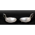 A pair of American Sterling silver dishes, early 20th century, the oval bowls cast with trailing flo... 