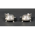 A pair of silver lidded mustard pots, of cauldron form with scroll handle and attached thumb pieces,... 