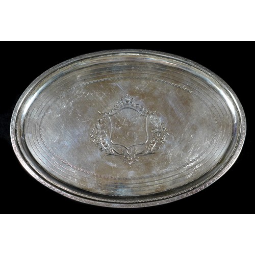 79 - A George III silver teapot stand, of oval form, with engraved wrigglework borders and central foliat... 