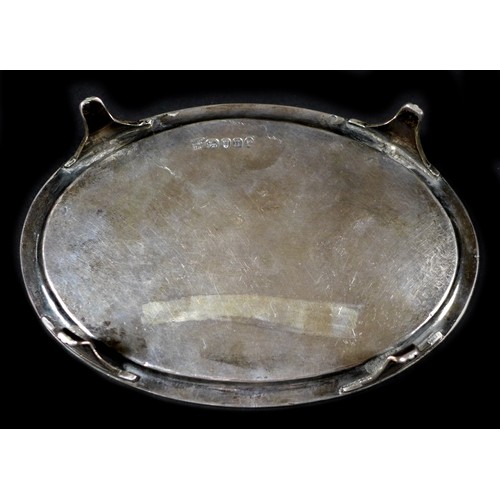 79 - A George III silver teapot stand, of oval form, with engraved wrigglework borders and central foliat... 