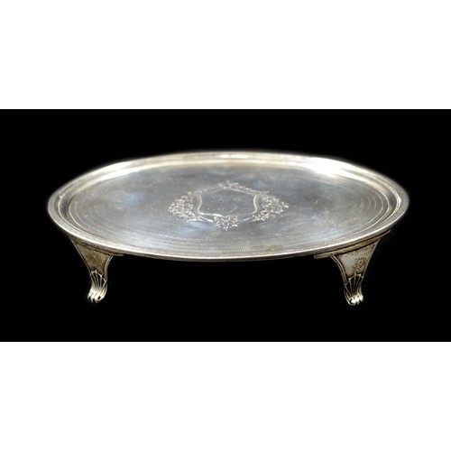 79 - A George III silver teapot stand, of oval form, with engraved wrigglework borders and central foliat... 